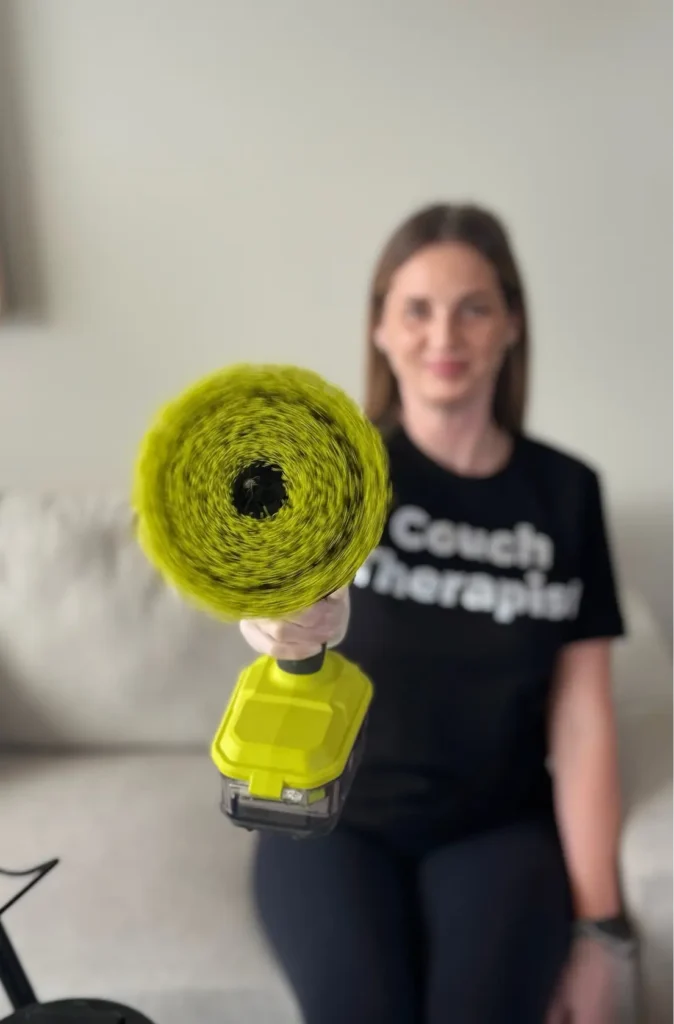 Upholstery cleaning specialist holding professional stain removal equipment
