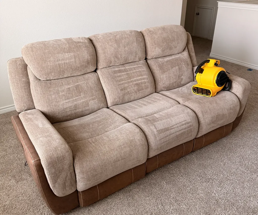 Professional upholstery cleaning service restoring a fabric couch to a fresh, clean condition